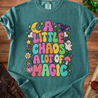 Teal t-shirt with colorful "A little chaos a lot of magic" text and whimsical graphics.