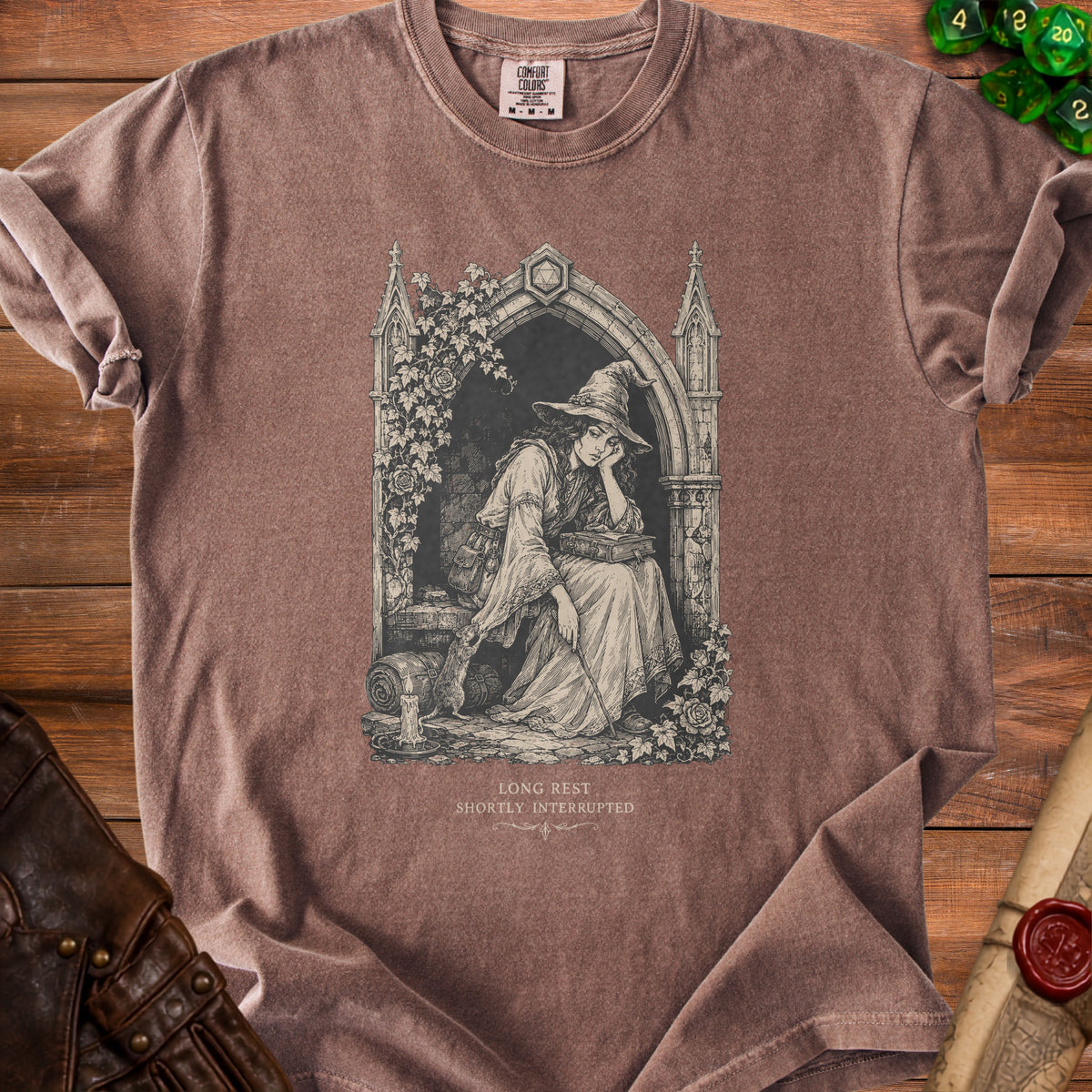 Brown t-shirt with gothic arch design of a witch reading, text "LONG REST SHORTLY INTERRUPTED".