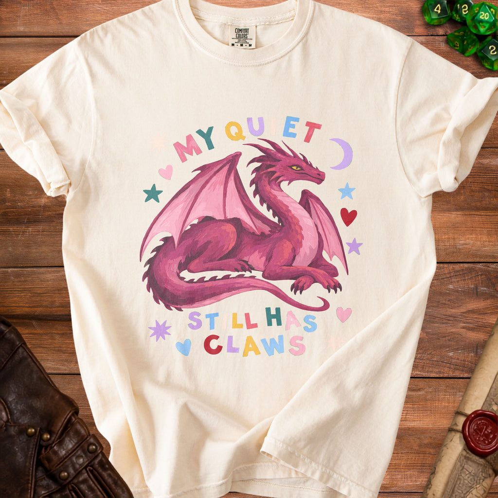 Cream t-shirt with pink dragon graphic and text "MY QUIET STILL HAS CLAWS".