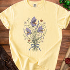Yellow t-shirt with a floral bouquet featuring carnivorous plants and pumpkins.
