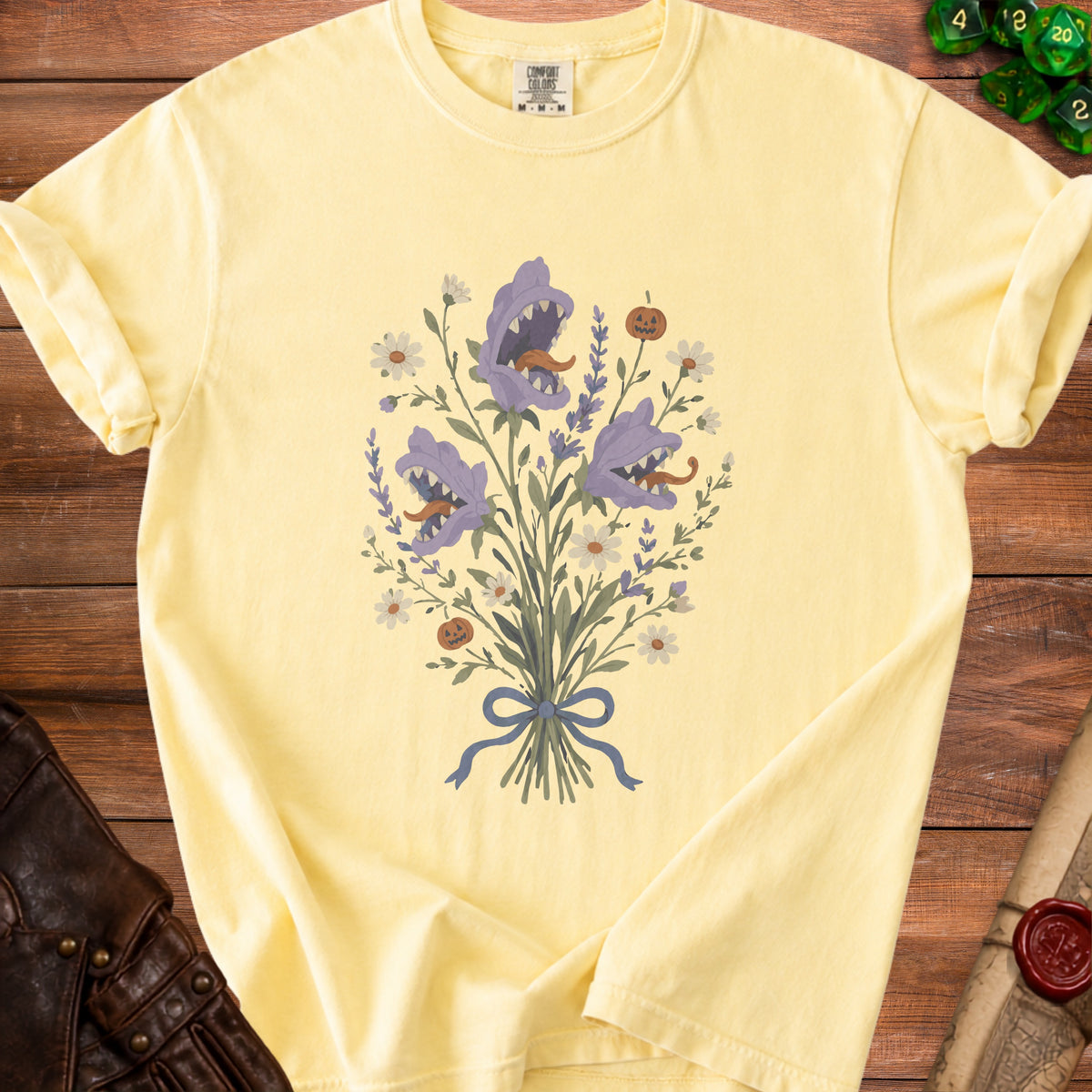 Yellow t-shirt with a floral bouquet featuring carnivorous plants and pumpkins.