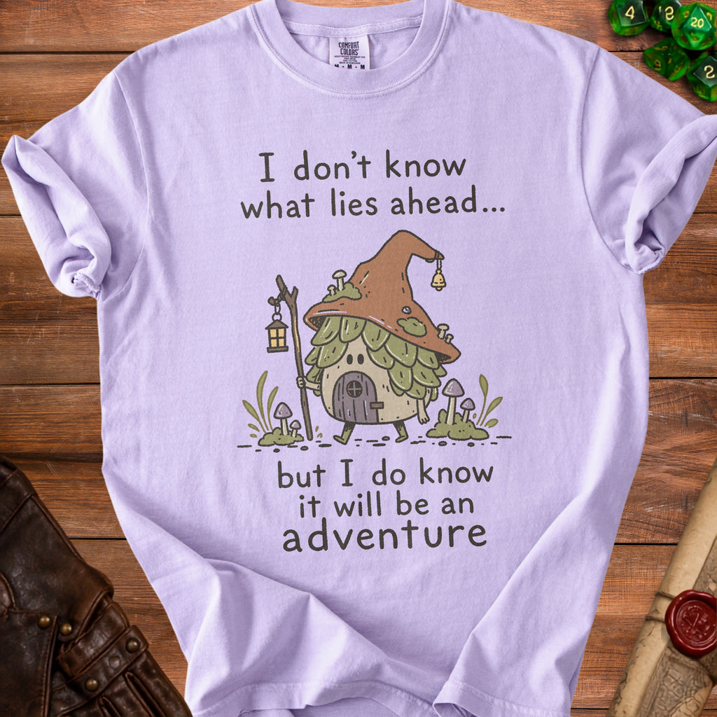 Purple t-shirt with illustration of a mushroom house and text "I don't know what lies ahead... but I do know it will be an adventure".