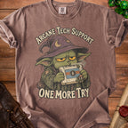 Brown t-shirt with wizard holding a retro game console, text reads "Arcane Tech Support One More Try".