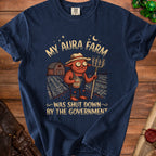 Graphic tee with a red creature holding a pitchfork and a bottle labeled "Aura Concentrate."