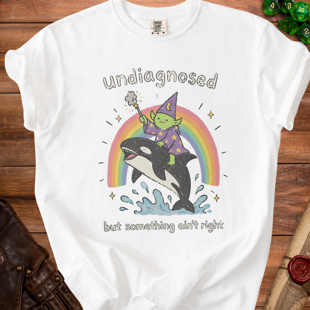 White t-shirt with graphic of green wizard riding orca across rainbow.