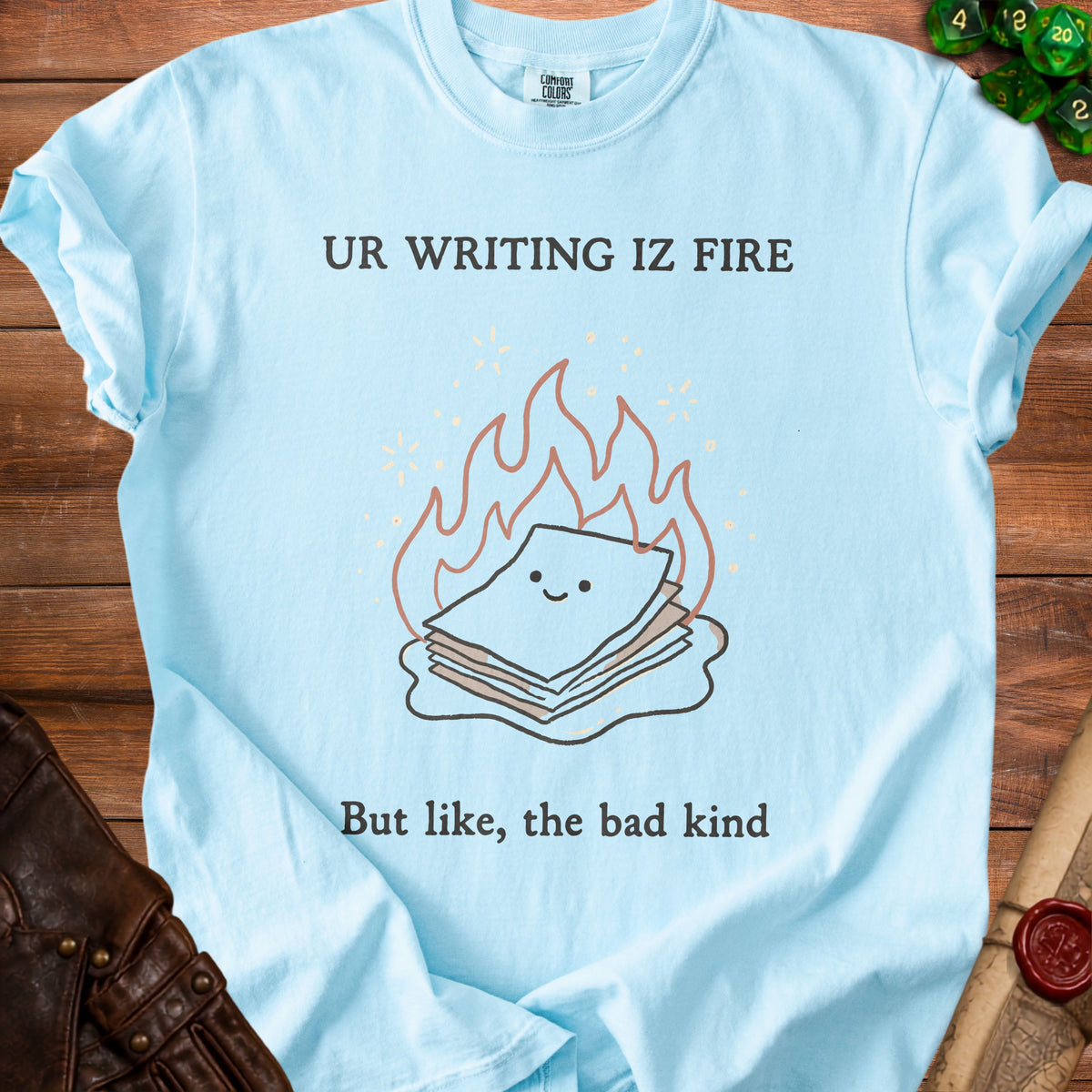 Light blue t-shirt with "UR WRITING IZ FIRE" and a burning stack of papers illustration.