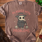 Brown t-shirt with plague doctor cartoon and text "Plagued With Problems".
