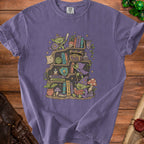 T-shirt with goblins reading and adventuring on a bookshelf.