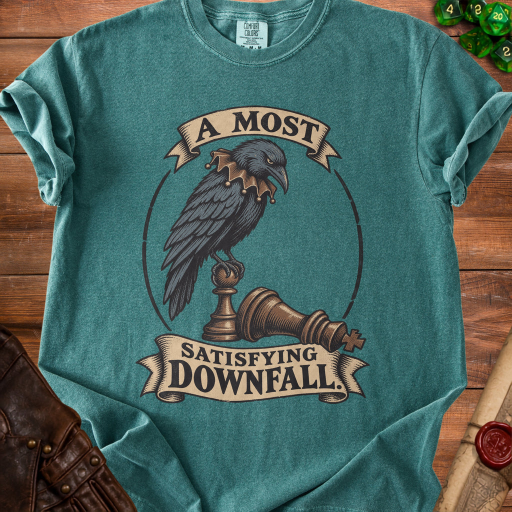 A teal t-shirt featuring a crow perched on a chess piece with the text A Most Satisfying Downfall.