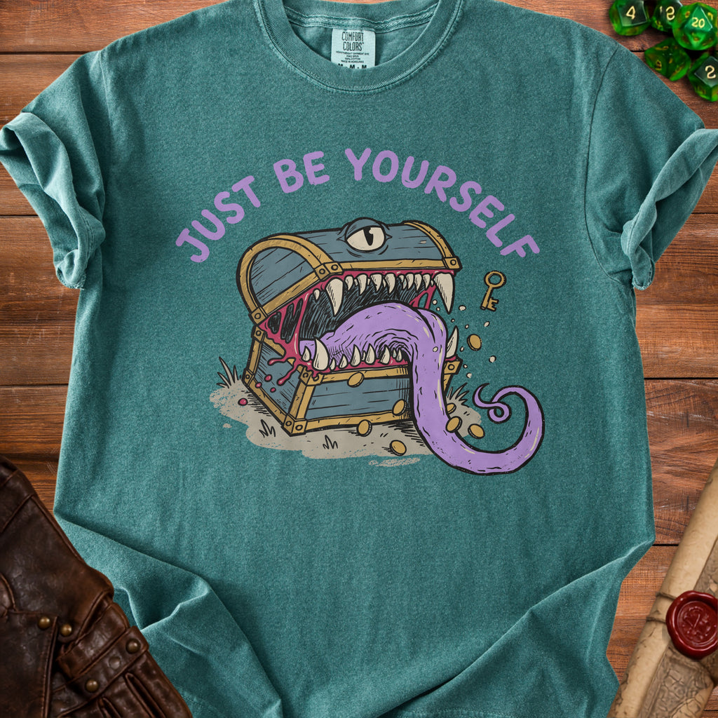 Teal t-shirt with purple text "JUST BE YOURSELF" and a monster treasure chest illustration.