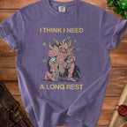 Purple t-shirt with gold text "I THINK I NEED A LONG REST" and knight graphic.