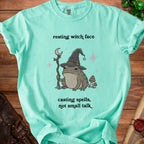 Mint green t-shirt with frog wizard, crescent moon staff, and text.