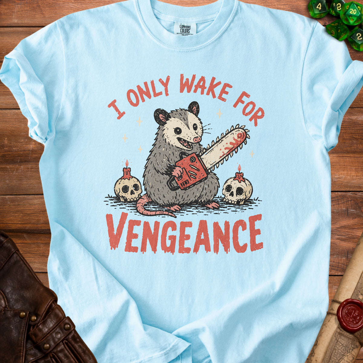 Light blue t-shirt with opossum holding chainsaw, skulls, and text "I ONLY WAKE FOR VENGEANCE".
