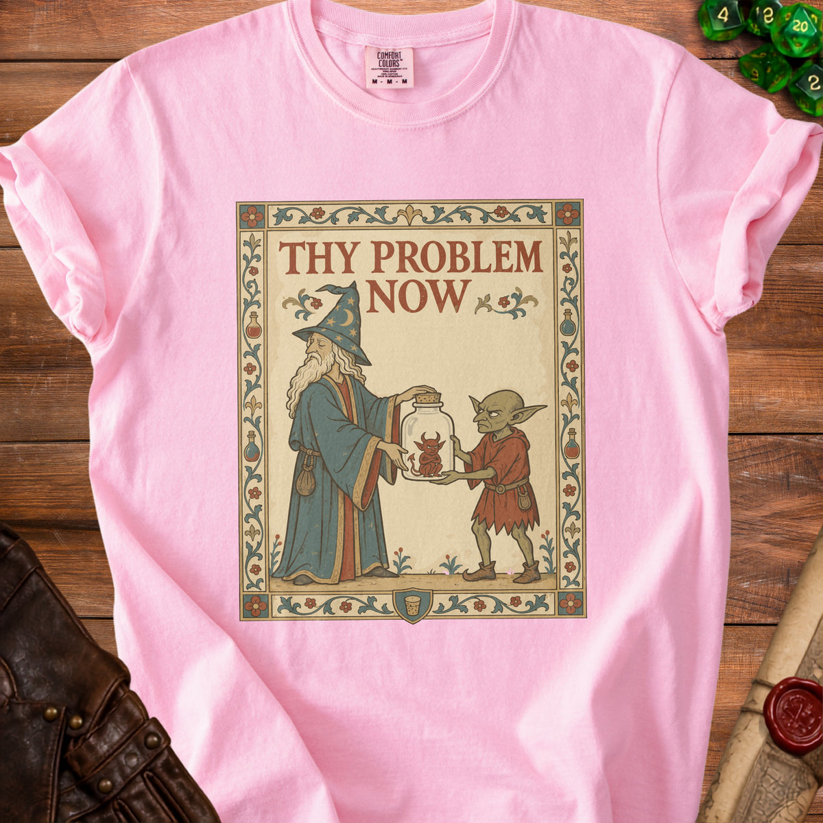 Pink t-shirt with "Thy Problem Now" text and wizard giving a jar to a goblin.