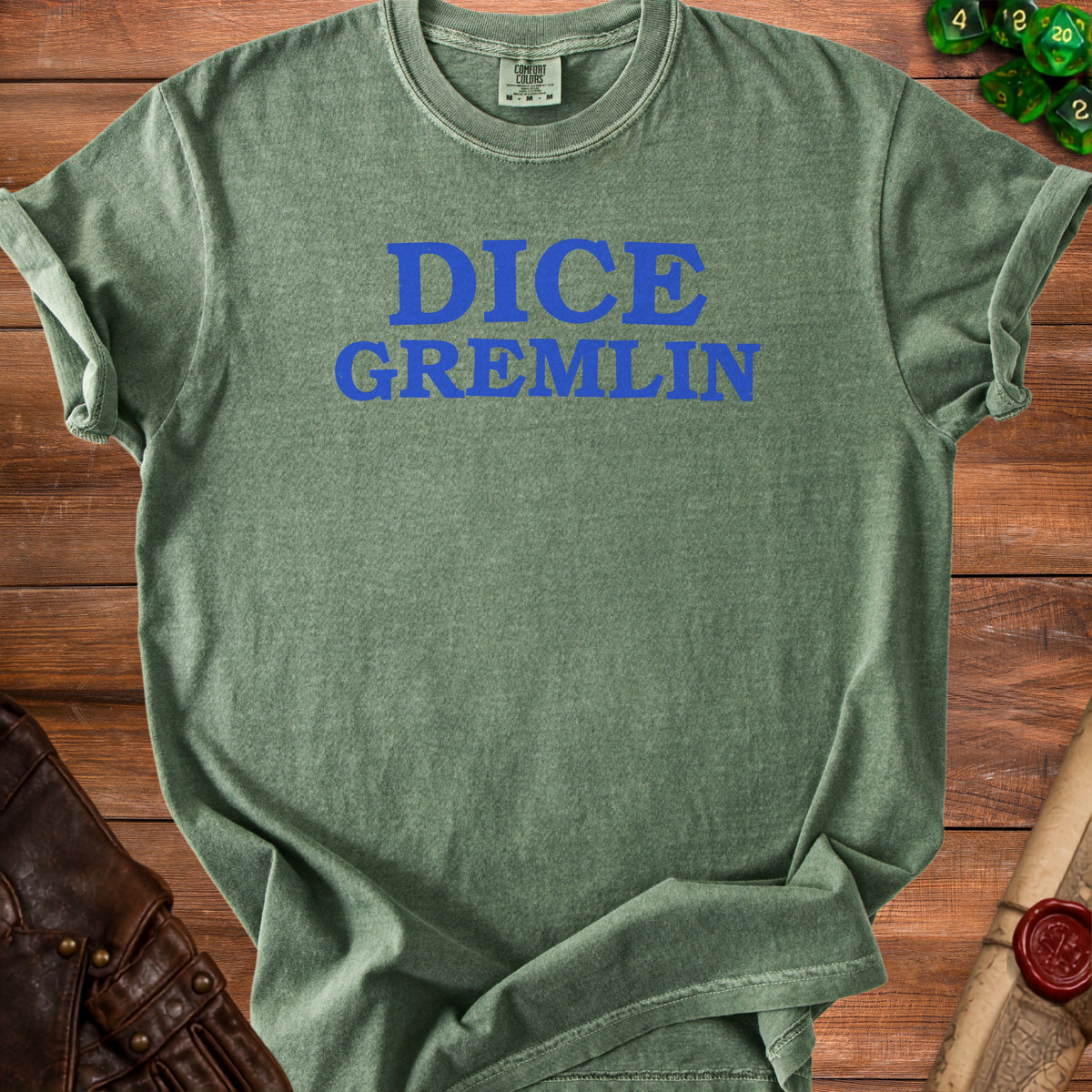 Green t-shirt with blue "DICE GREMLIN" text, dice, and leather cuff.