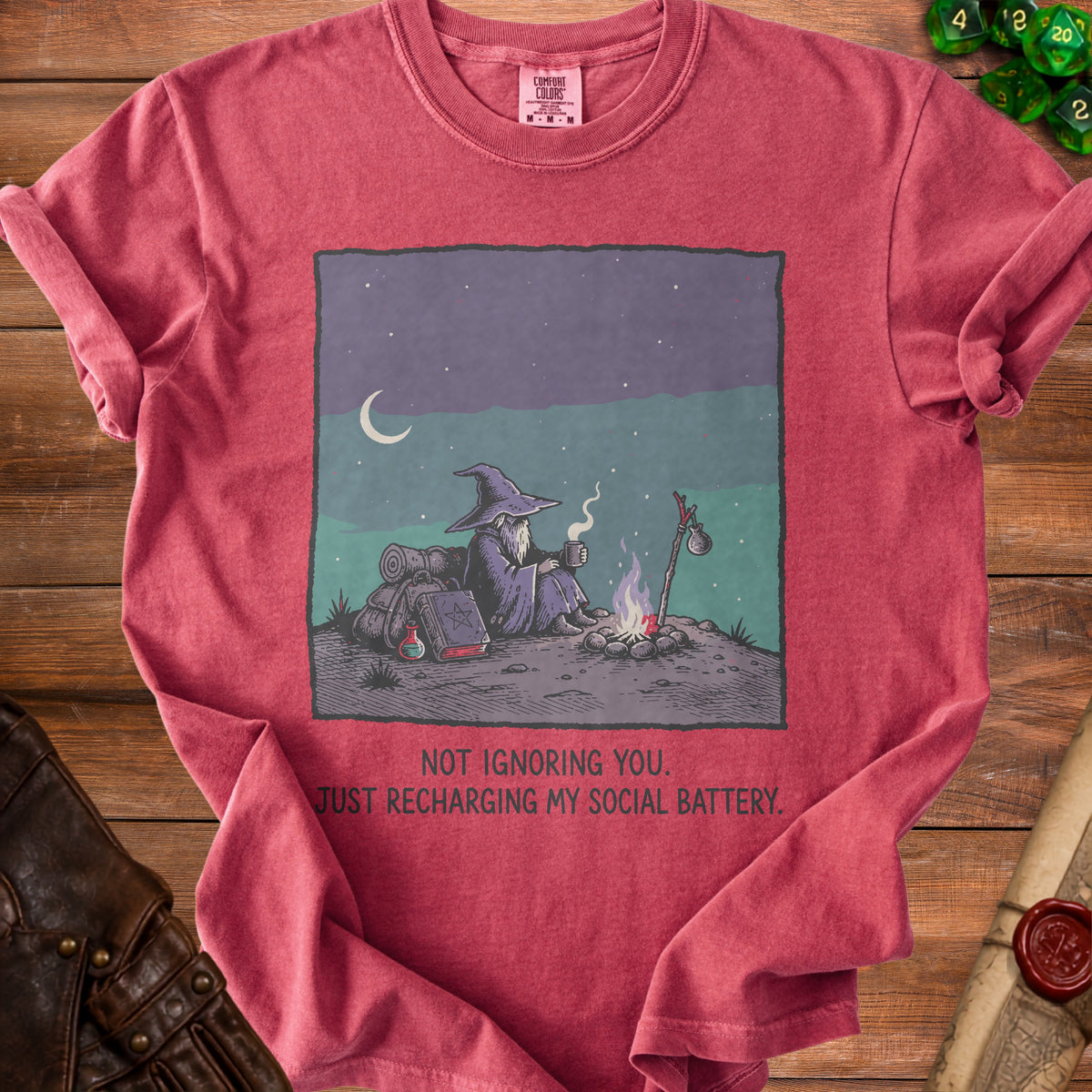 T-shirt with illustration of a wizard by a campfire and text "Not ignoring you. Just recharging my social battery."