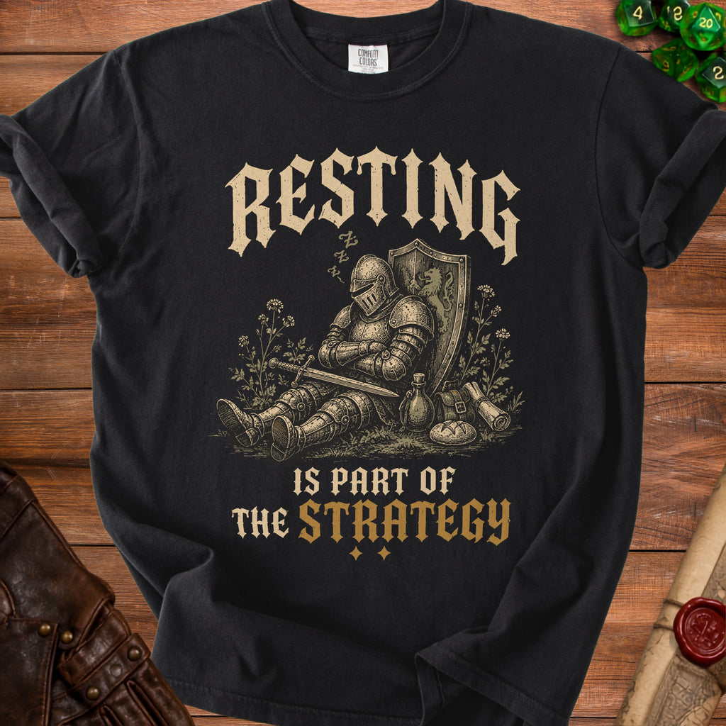 Black t-shirt with knight sleeping next to shield and sword, text "Resting is part of the strategy."