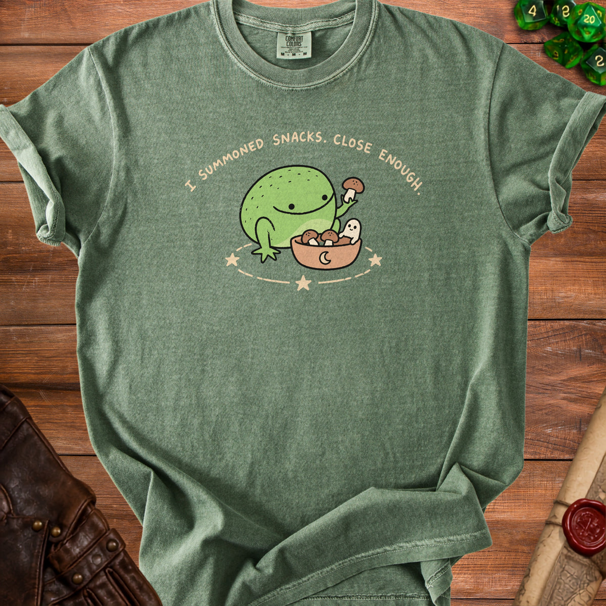 Green t-shirt with cartoon frog holding mushroom, reading "I summoned snacks. Close enough."