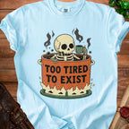 Light blue t-shirt with a skeleton in a pot of coffee, text "TOO TIRED TO EXIST".