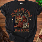 Graphic tee with devil on throne, skulls, and text "It's Hell Out There Stay Inside."