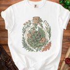 White t-shirt with a bottle terrarium featuring dice, mushrooms, and foliage graphic.