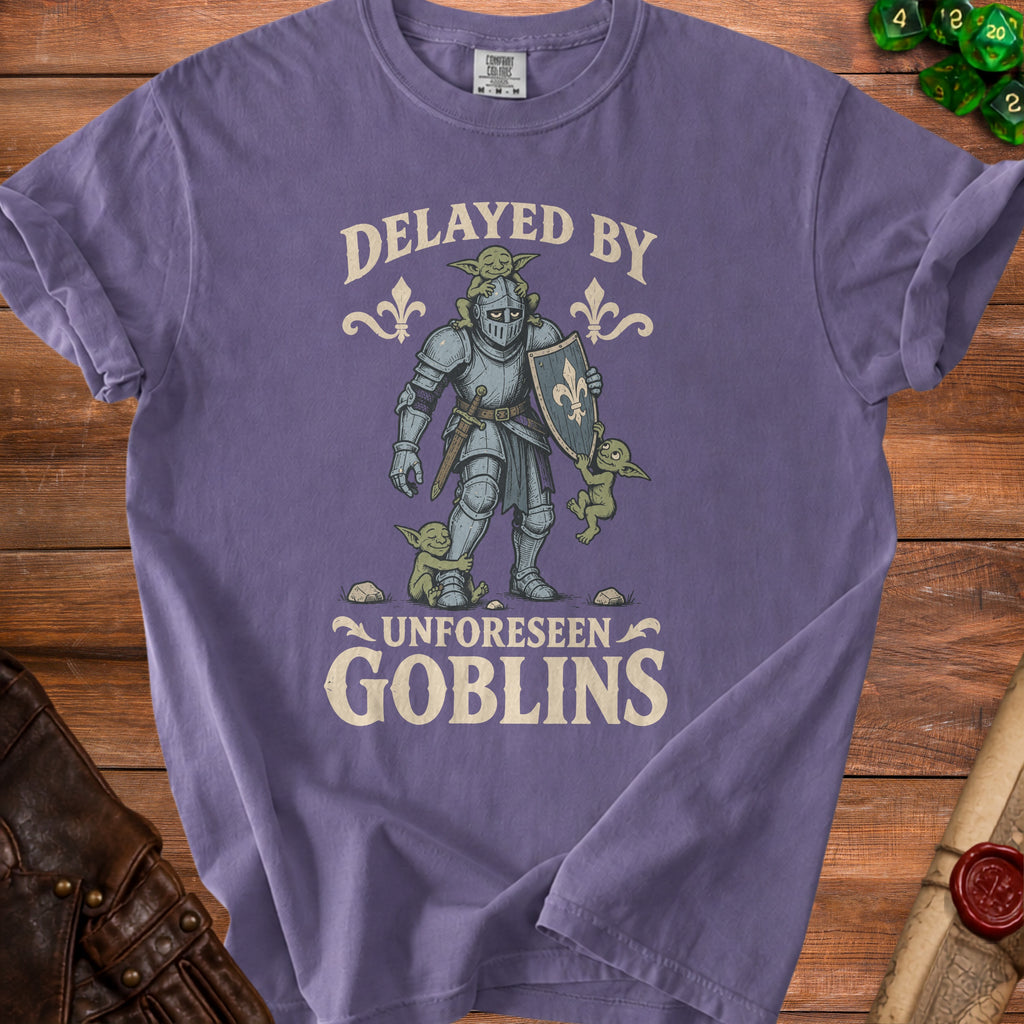 T-shirt with knight and goblins graphic, reads "Delayed by Unforeseen Goblins."