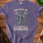 T-shirt with knight and goblins graphic, reads "Delayed by Unforeseen Goblins."