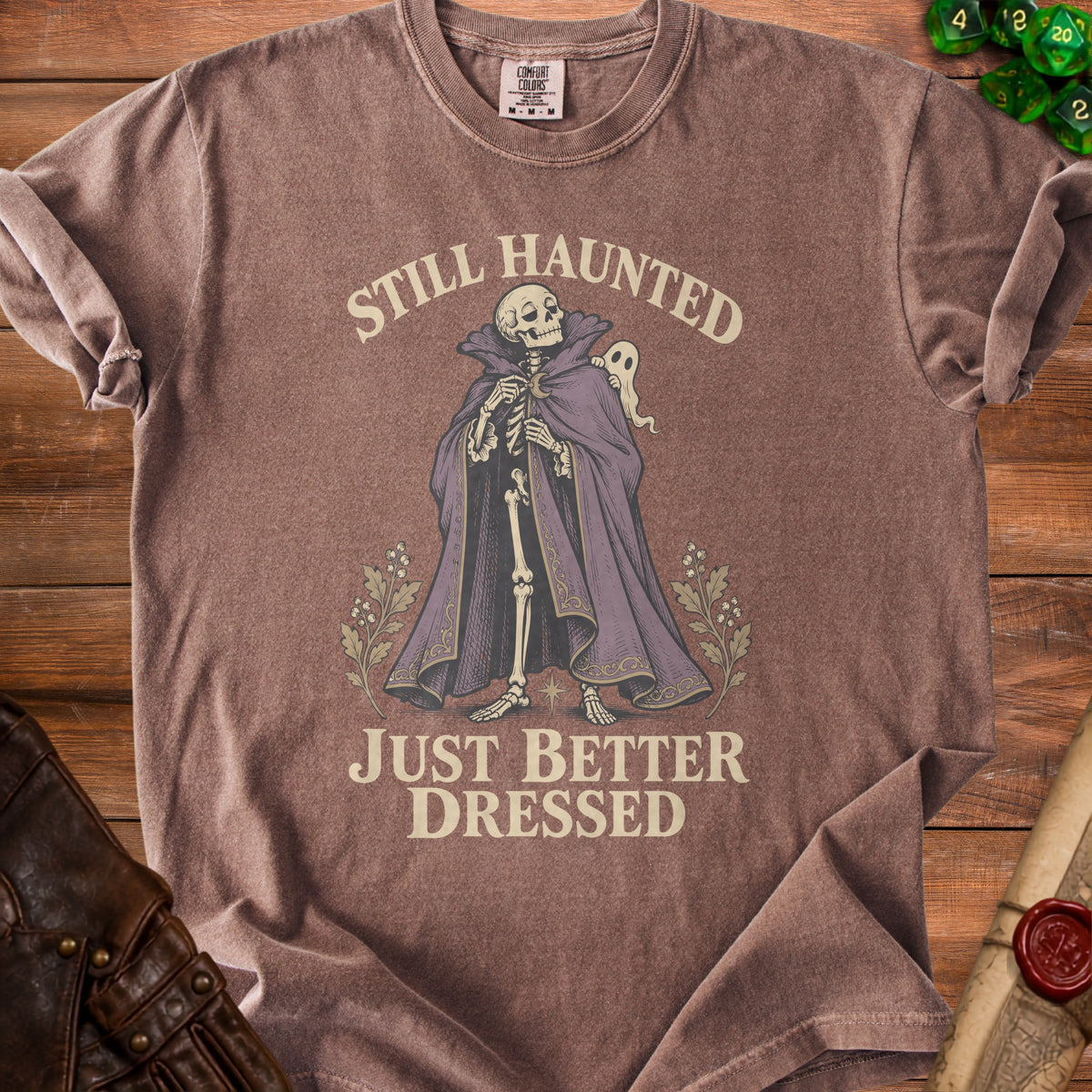 Skeleton in ornate cape with ghost and text "Still Haunted Just Better Dressed".
