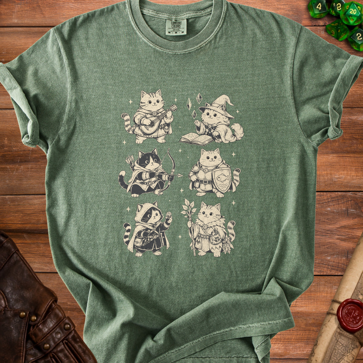 Sage green t-shirt featuring a front print of six fantasy cats dressed as role-playing adventurers.