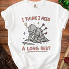 White t-shirt with a cartoon knight pierced by arrows, reading "I THINK I NEED A LONG REST".