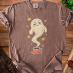 Brown t-shirt with a whimsical ghost emerging from a coffee cup, surrounded by stars.