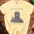 Yellow t-shirt with a goblin wizard and text "Are we back in medieval times? cause everything sure is mid and evil".