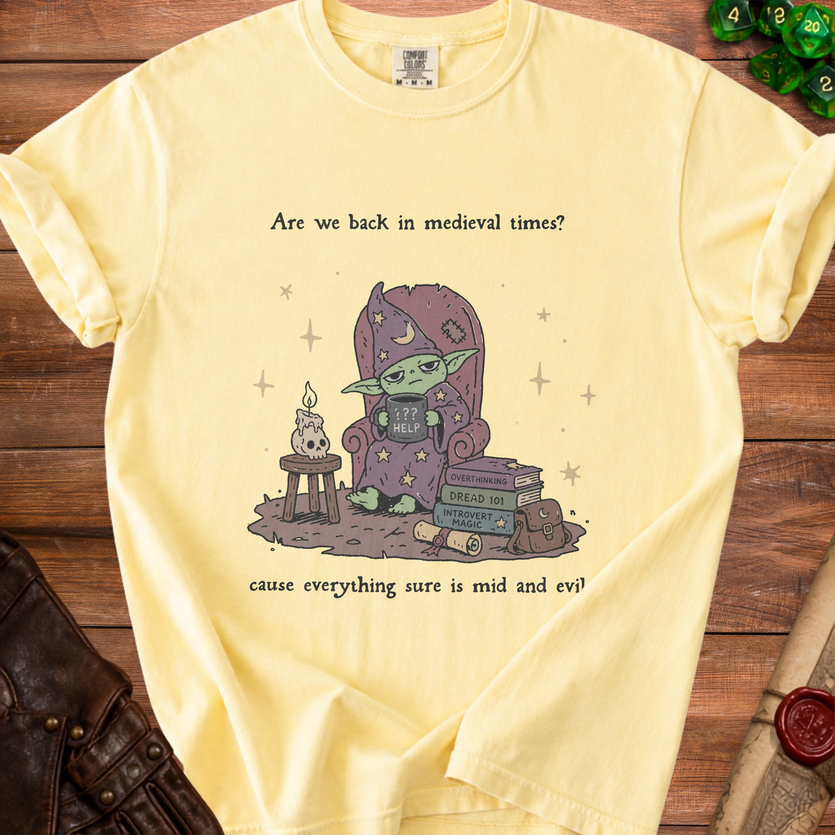 Yellow t-shirt with a goblin wizard and text "Are we back in medieval times? cause everything sure is mid and evil".