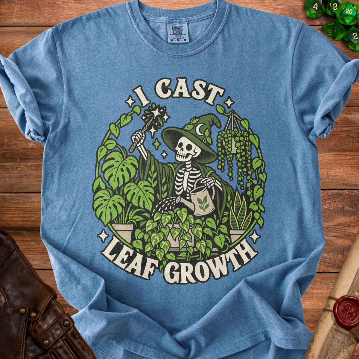 Blue t-shirt with skeleton wizard and plants graphic and "I CAST LEAF GROWTH" text.