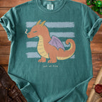 Teal t-shirt with an orange dragon design and "out of fire" text.