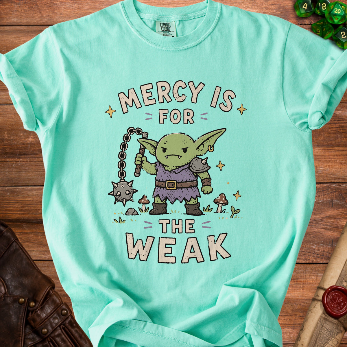 Teal t-shirt with a cartoon goblin holding a flail, reading "Mercy is for the weak."