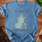 Blue t-shirt with a drawing of a wizard goblin holding a long scroll, "My Quest Log Needs Boundaries".