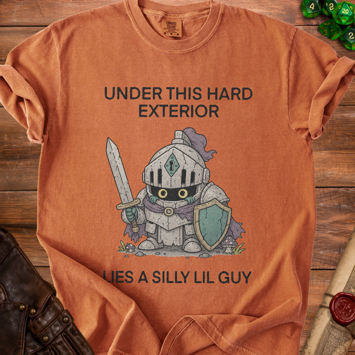 Orange shirt with a cartoon knight graphic and text "Under This Hard Exterior Lies A Silly Lil Guy".