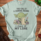 Goblin with scroll and books on light blue t-shirt; "You call it a criminal record, I call it my lore."