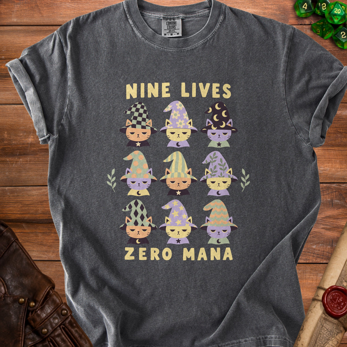 Dark gray t-shirt with "NINE LIVES ZERO MANA" text and nine cartoon cats in wizard hats.