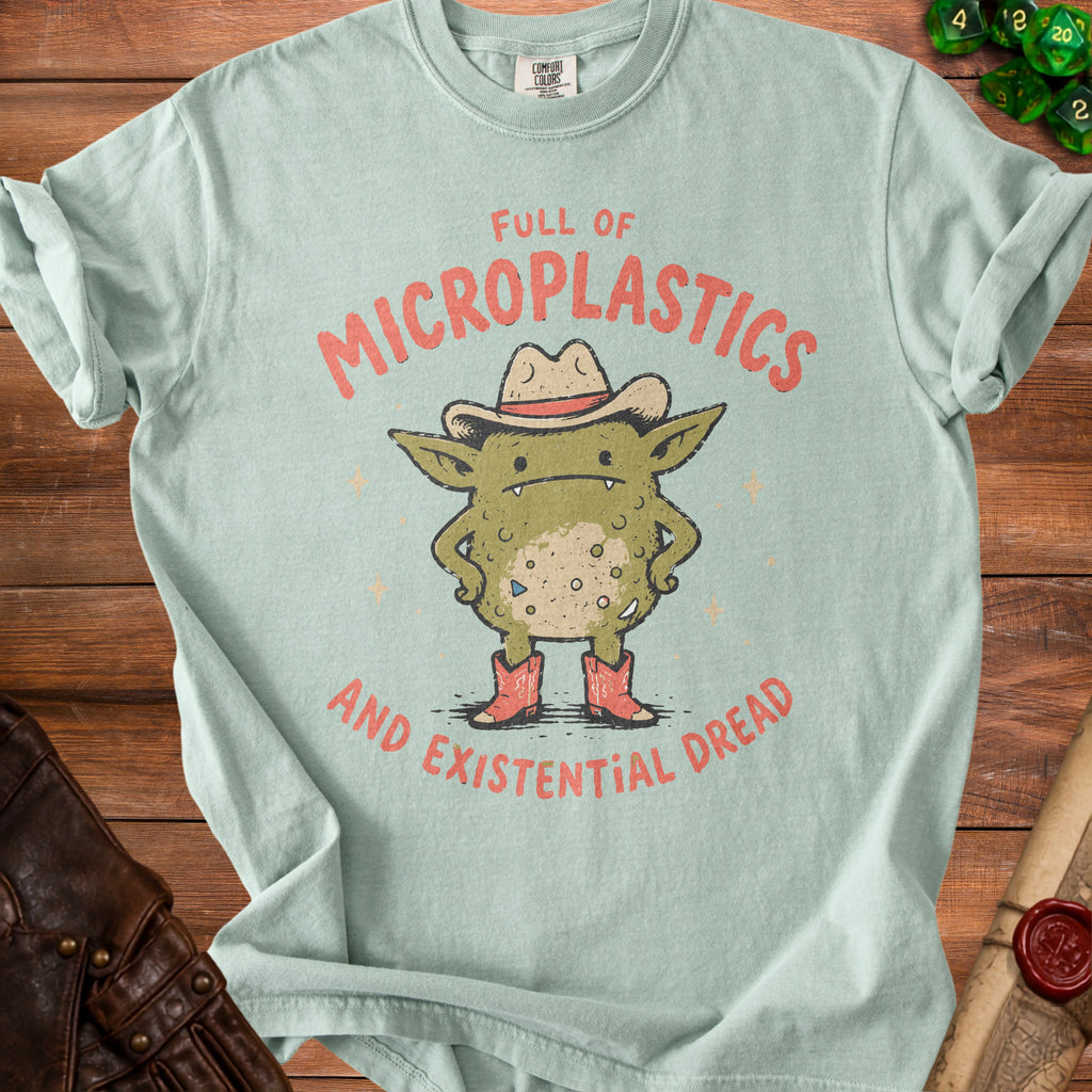 Light blue t-shirt with graphic of green creature saying "Full of Microplastics and Existential Dread".