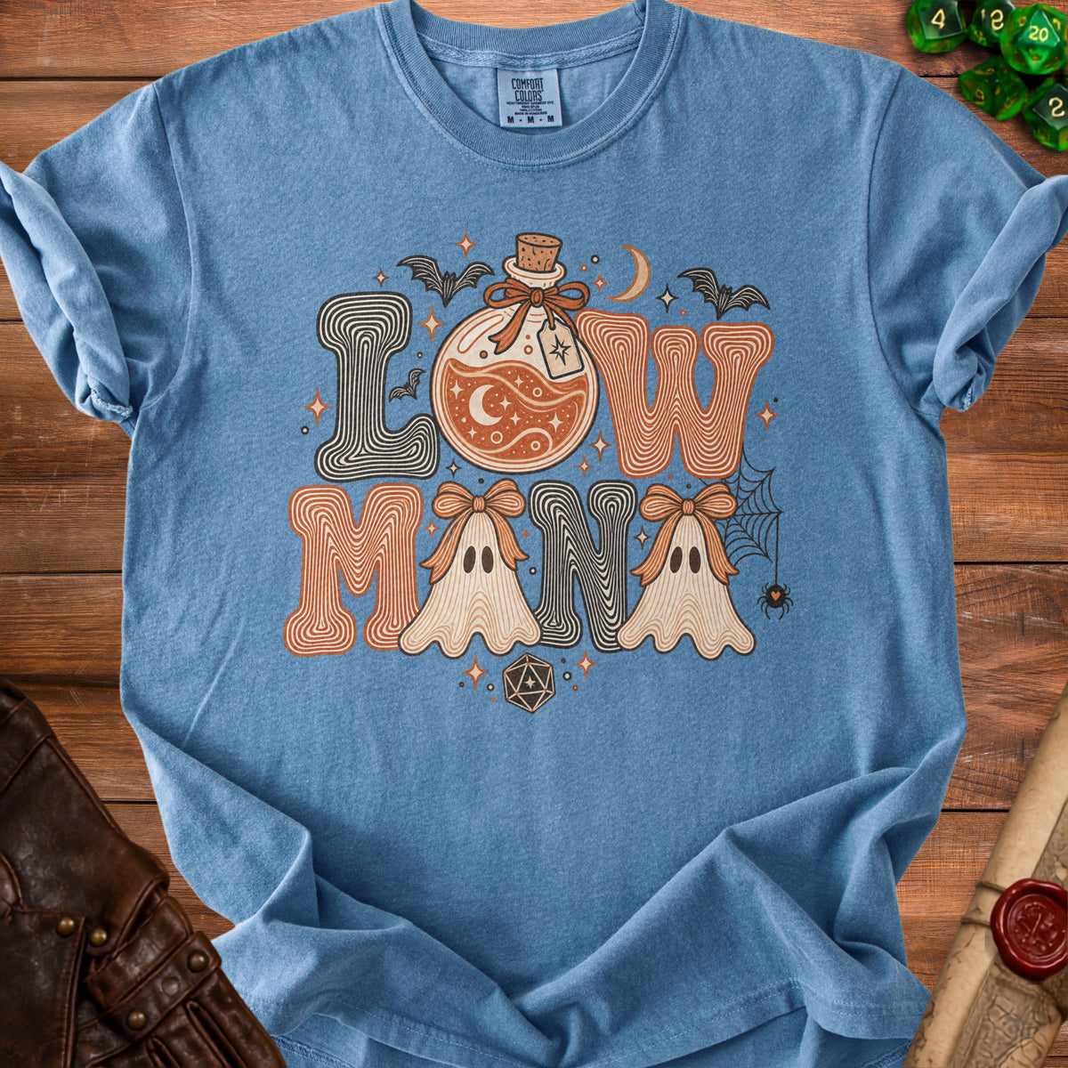 Blue t-shirt with "LOW MANA" text featuring potion, ghosts, bats, and dice.