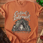 Orange t-shirt with "Critical Introvert" graphic of a ghost in a tent holding a d20.