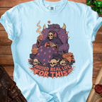 Light blue t-shirt with grim reaper playing video games and text "Paused Real Life For This".