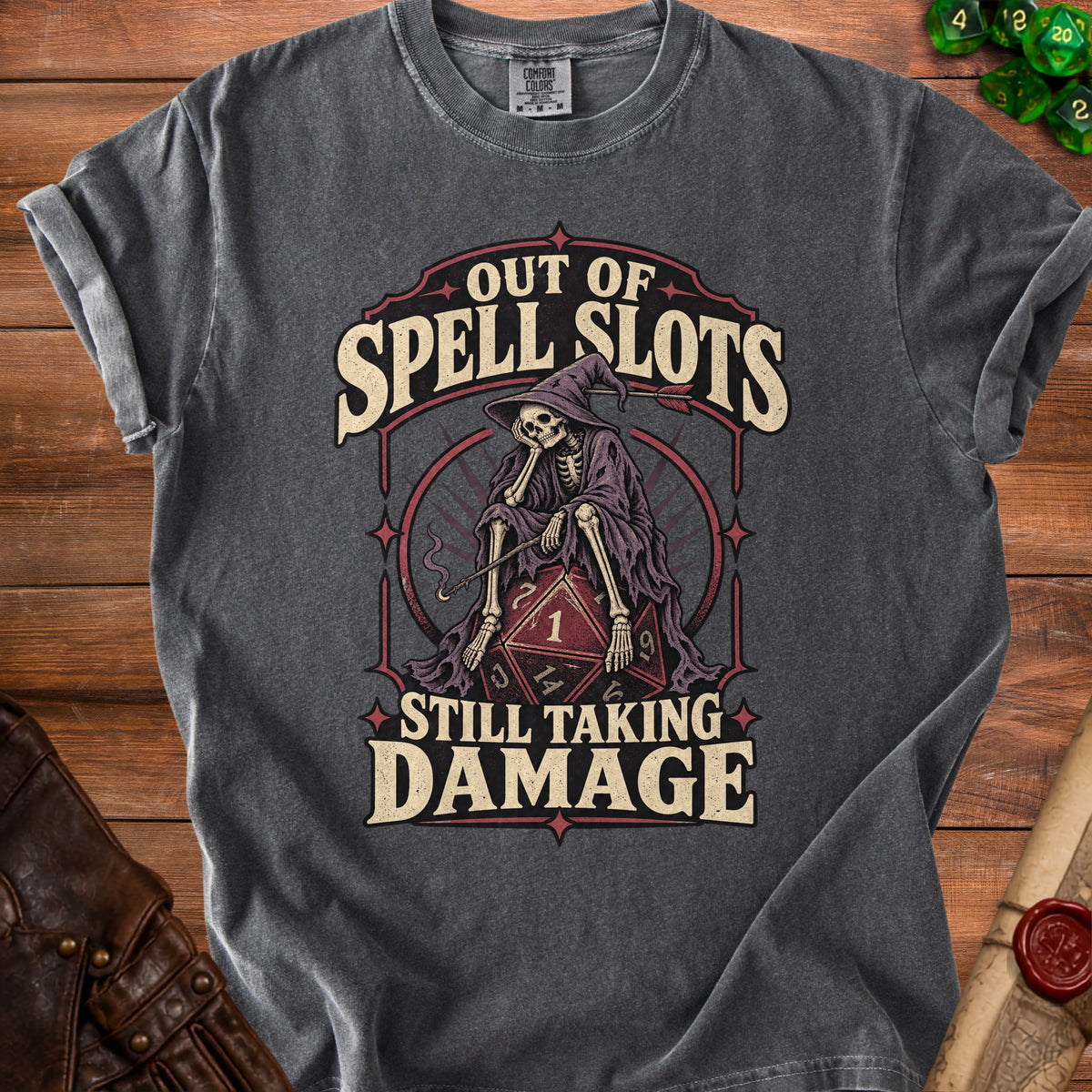 Dark grey t-shirt with skeleton graphic and text "Out of Spell Slots Still Taking Damage".