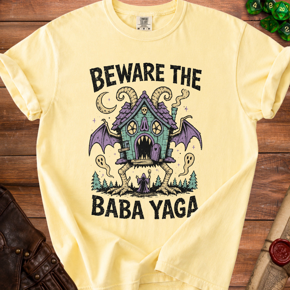 Yellow t-shirt with "Beware the Baba Yaga" text and a spooky house graphic.