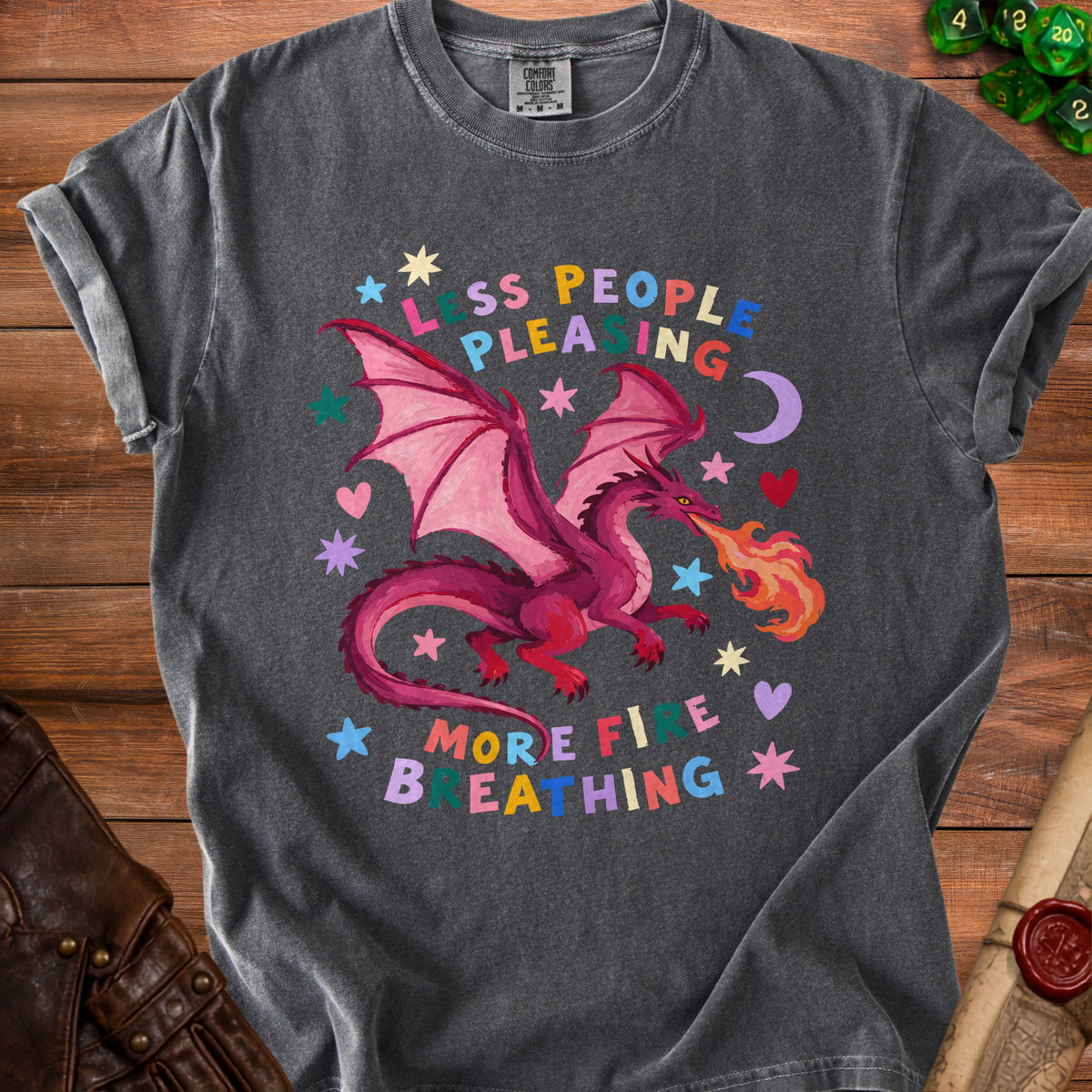 Dark gray t-shirt with a pink dragon breathing fire and the text "less people pleasing, more fire breathing."