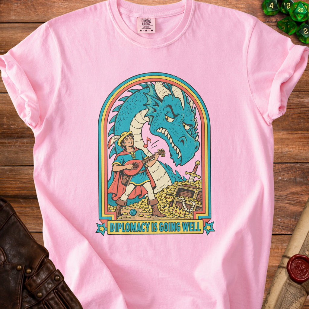 Pink t-shirt with "Diplomacy Is Going Well" text and a man playing lute before a dragon.