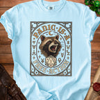 Light blue t-shirt with raccoon graphic and "PANIC IS FREE ACTION" text.