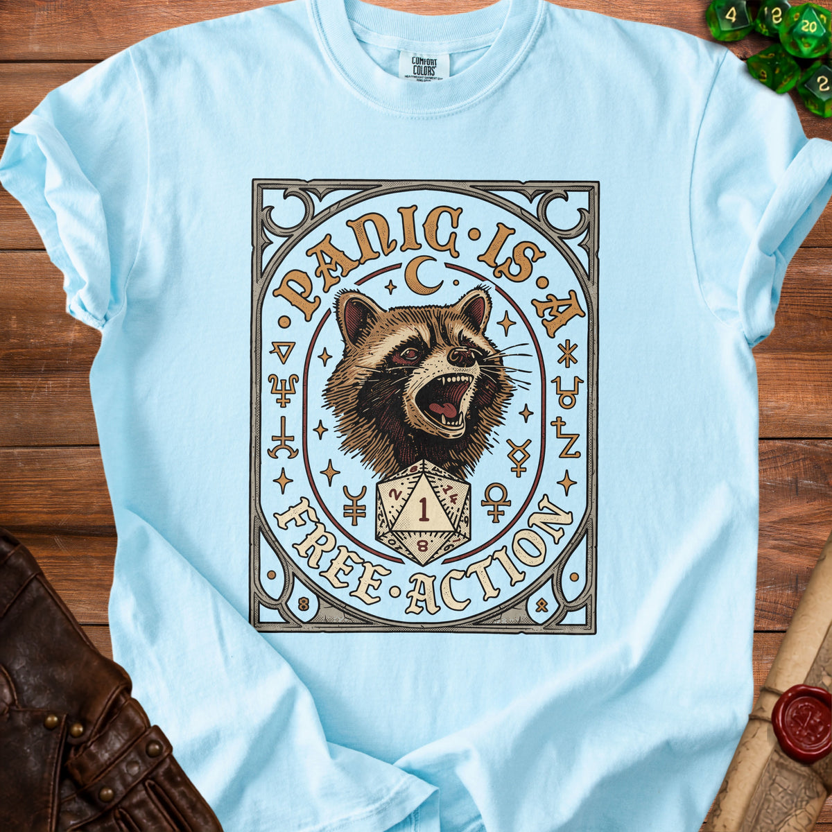 Light blue t-shirt with raccoon graphic and "PANIC IS FREE ACTION" text.